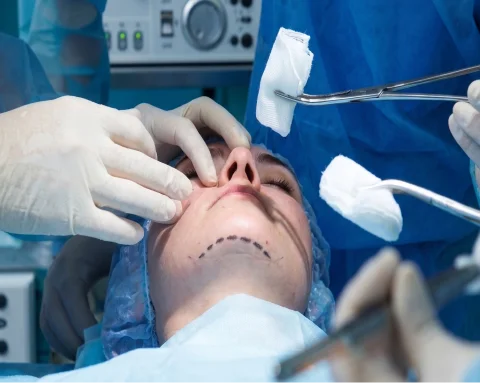 Close-up of doctor reviewing healing nose showing rhinoplasty process