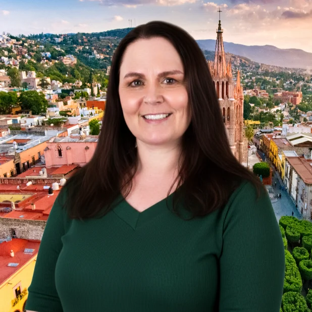 Woman in San Miguel de Allende, smiling after receiving All on 4 dental implants, with a baroque church in the background.