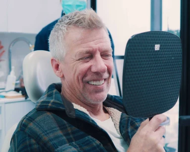 patient smiling joyfully after full arch restoration