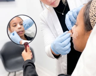 Patient seeing results post-surgery with medical support nearby