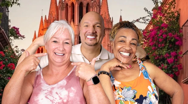 Patient smiling in front of the iconic church of San Miguel de Allende.