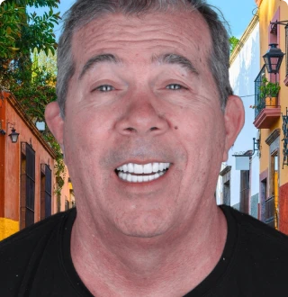 Adult man with visible signs of aging smiling proudly with teeth restored to a natural look